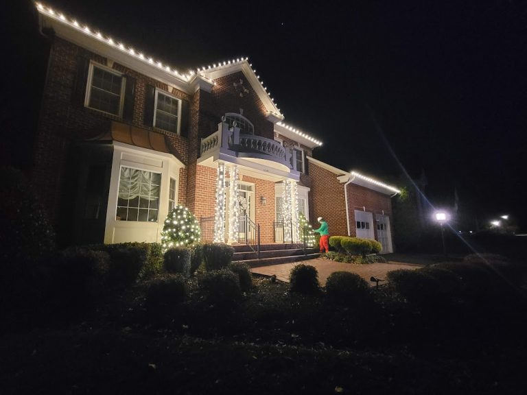 Warm white roofline Christmas lights installed by Lights Around on a two-story brick home in Northern Virginia