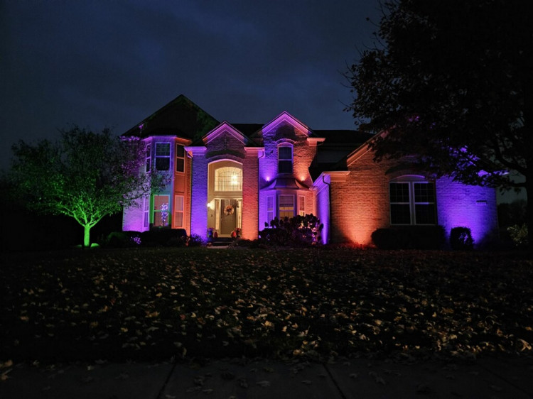Professional exterior holiday uplighting on a two-story Virginia home at night
