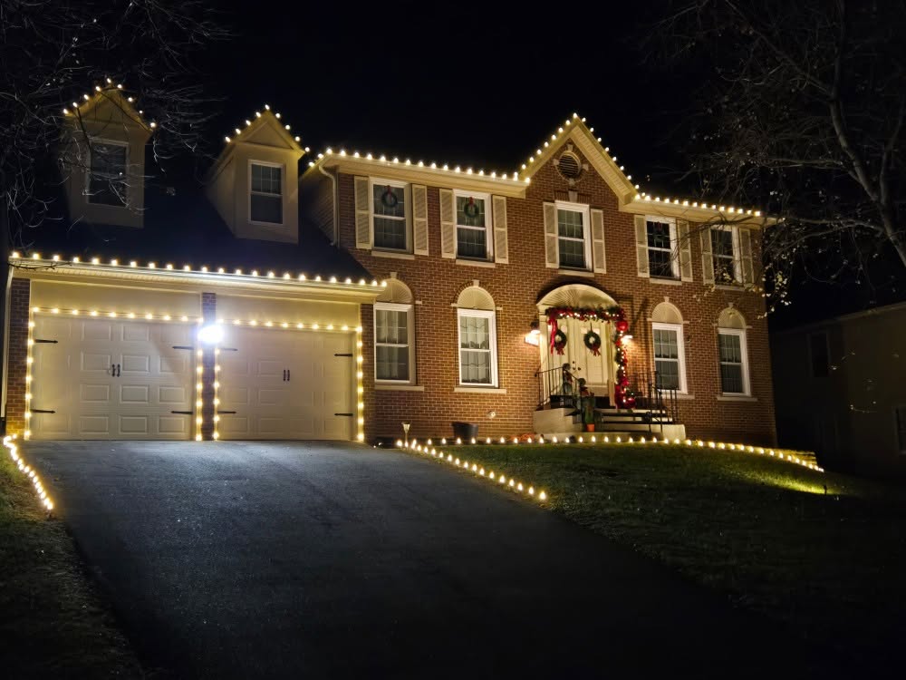 Warm white C9 roofline, garage and walkway lights on a brick colonial in Arlington, VA