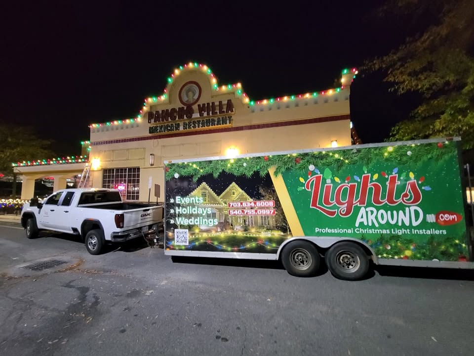 Lights Around installation truck and branded trailer at a commercial Christmas lighting job