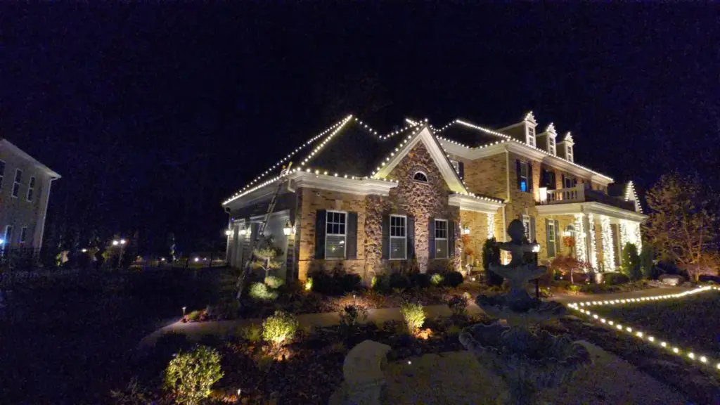 Warm white Christmas lights on a large brick and stone home